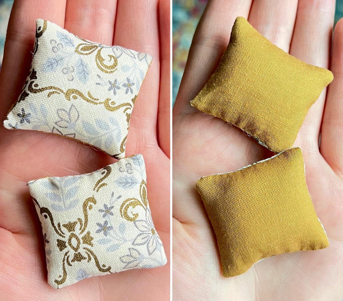 Two small fabric pillows, front  with floral pattern and back plain mustard yellow, held in hands.