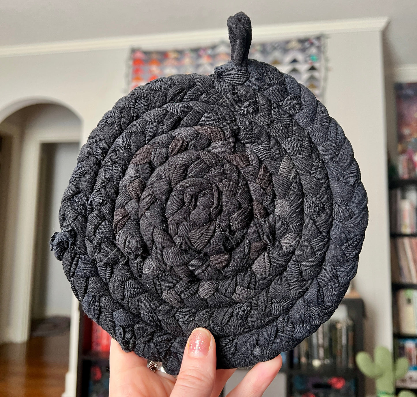 Trivet potholder single black, held up to show scale and texture