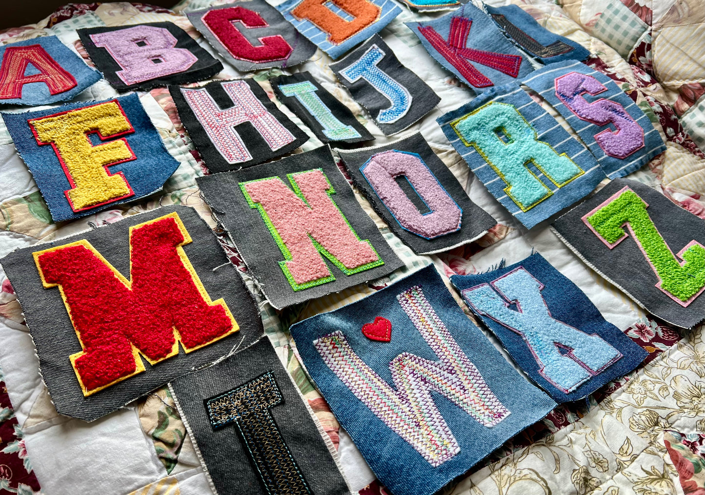 Colorful embroidered letters on a textured fabric background