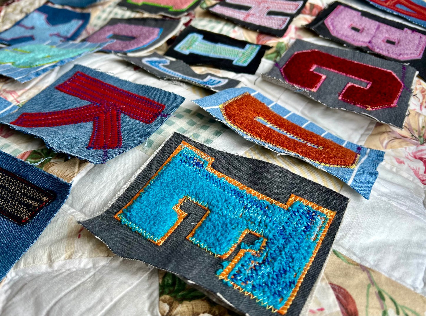 Collection of colorful embroidered patches on a textured fabric background