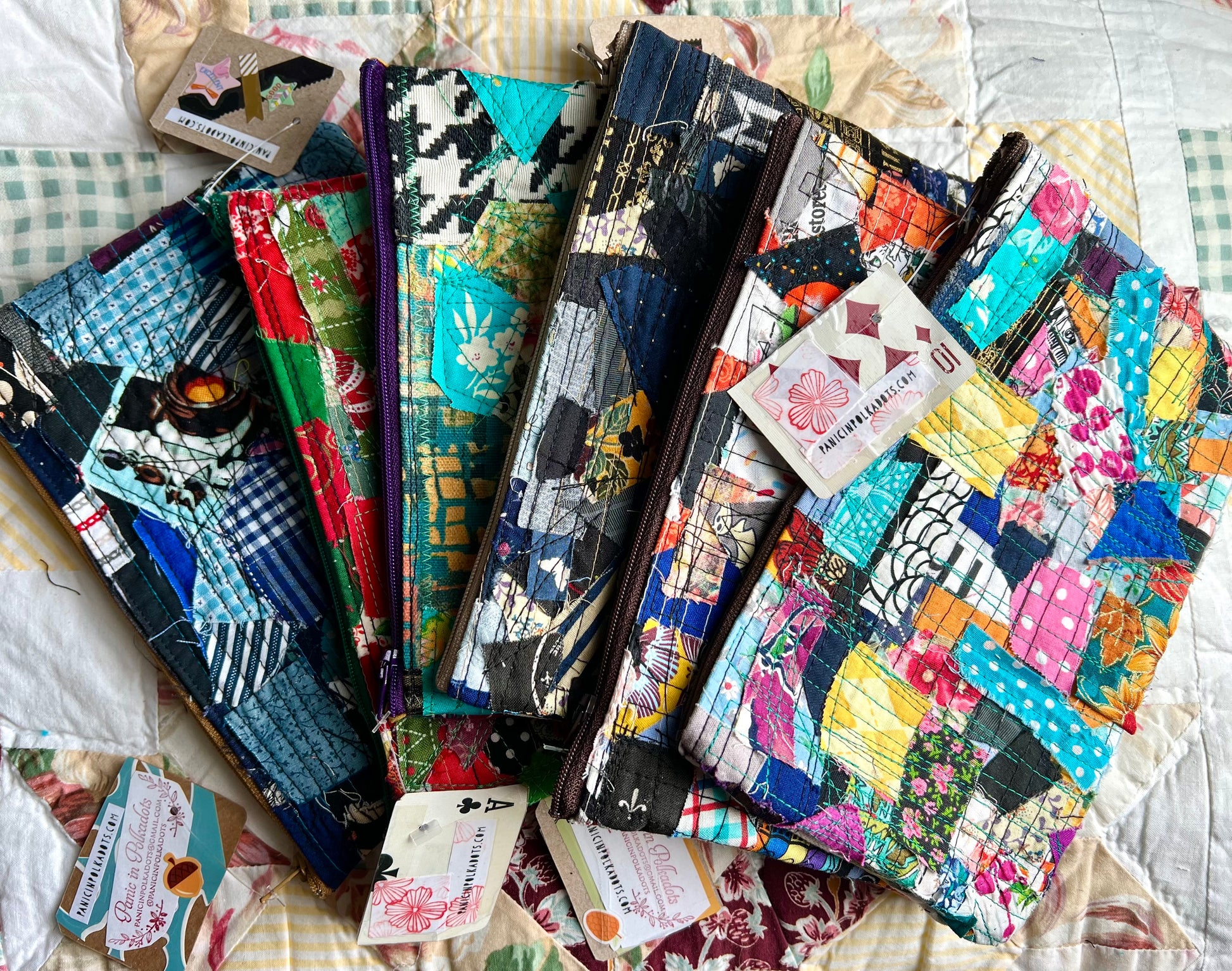 Collection of colorful fabric zipper pouches on a quilt