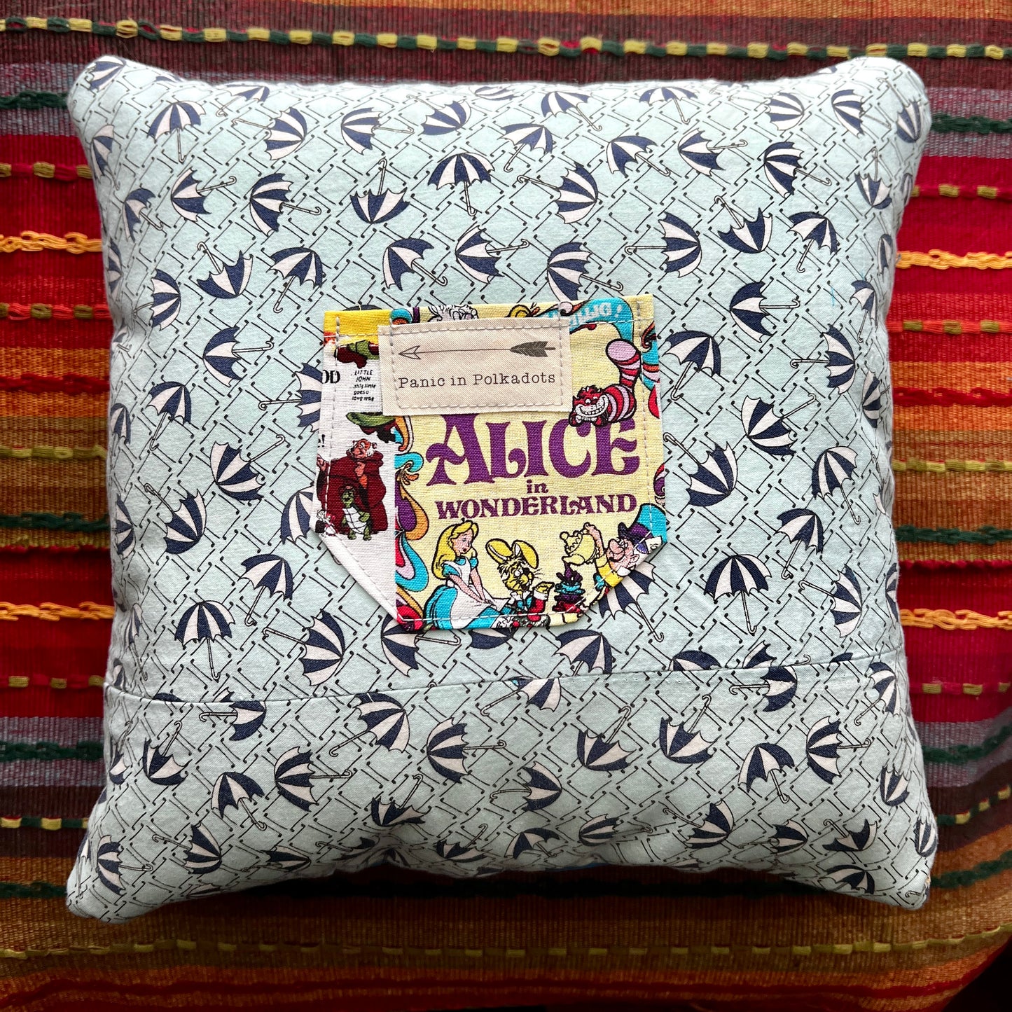 back view of alice in wonderland cathedral square pillow, with umbrellas and movie poster pocket