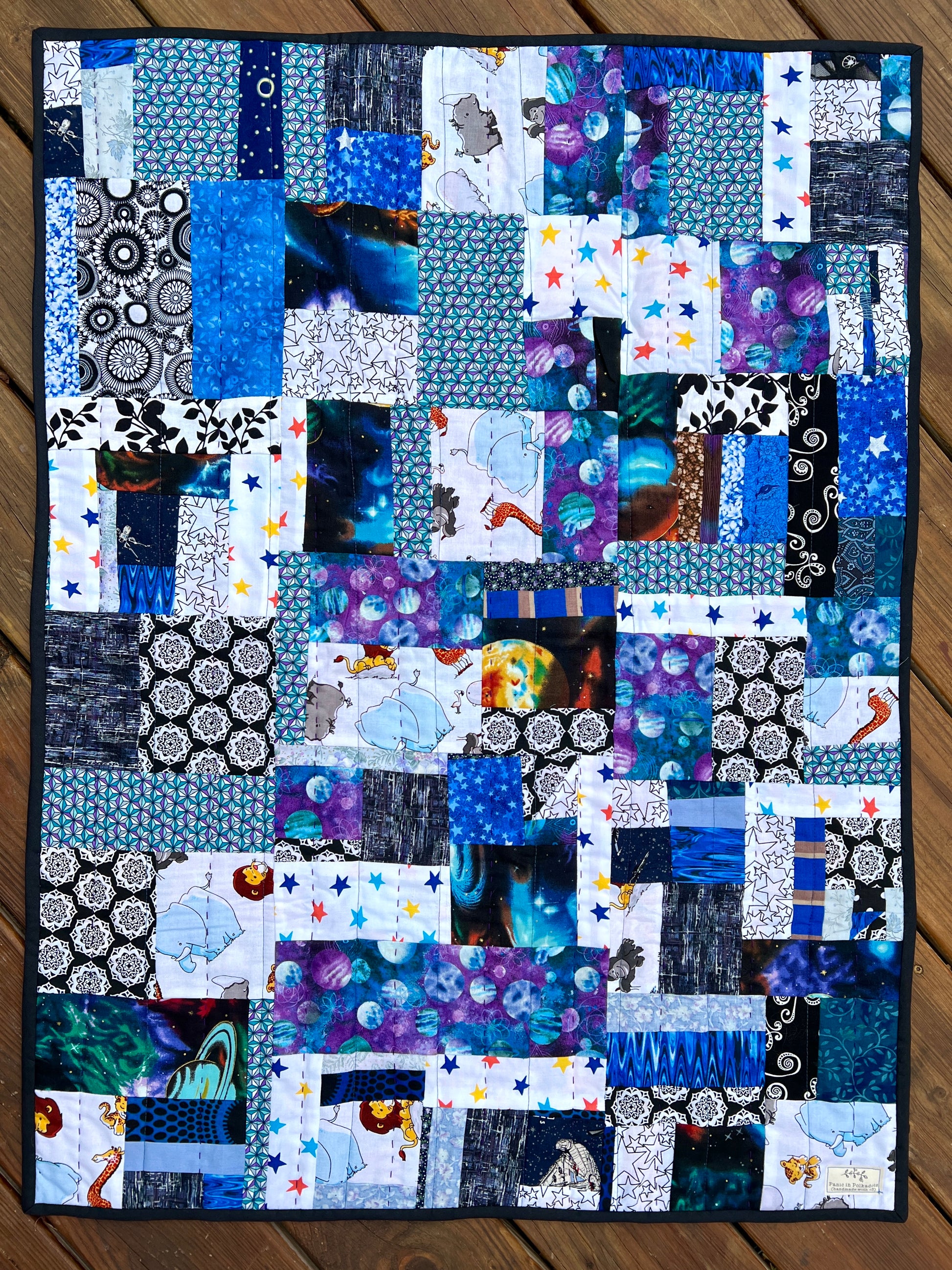 a baby sized or pet quilt stars and zoo animals in blues and purples, aerial view