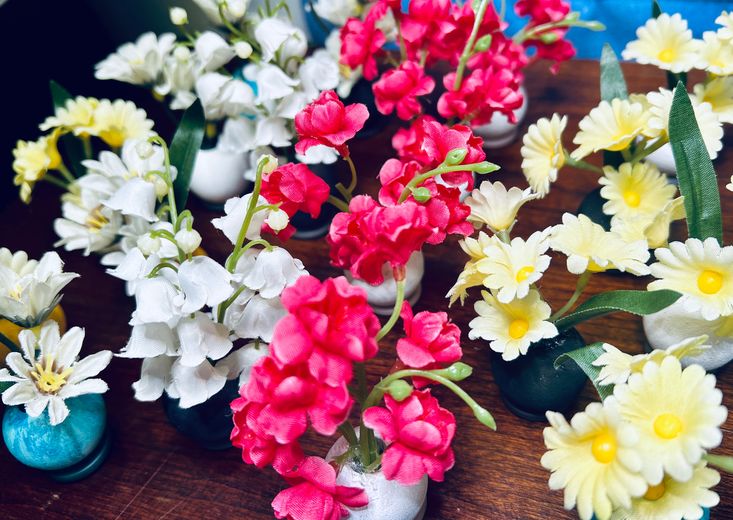 a bunch of miniature vases, various flowers