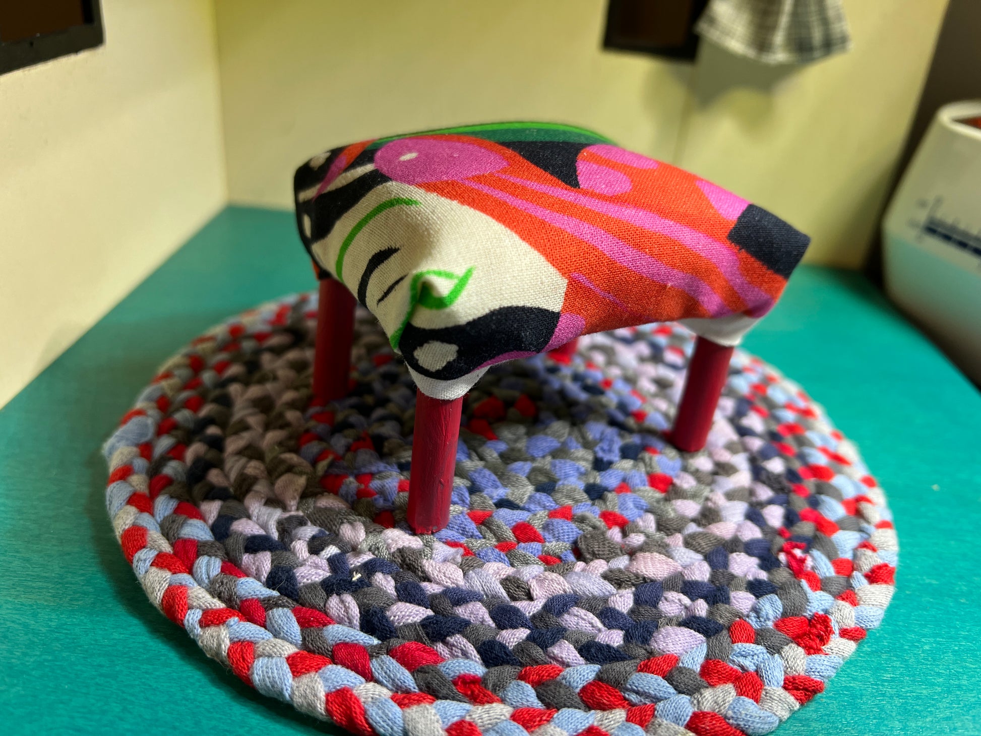 barbie ottoman in snake and leaves fabric, on top of a miniature rug for styling