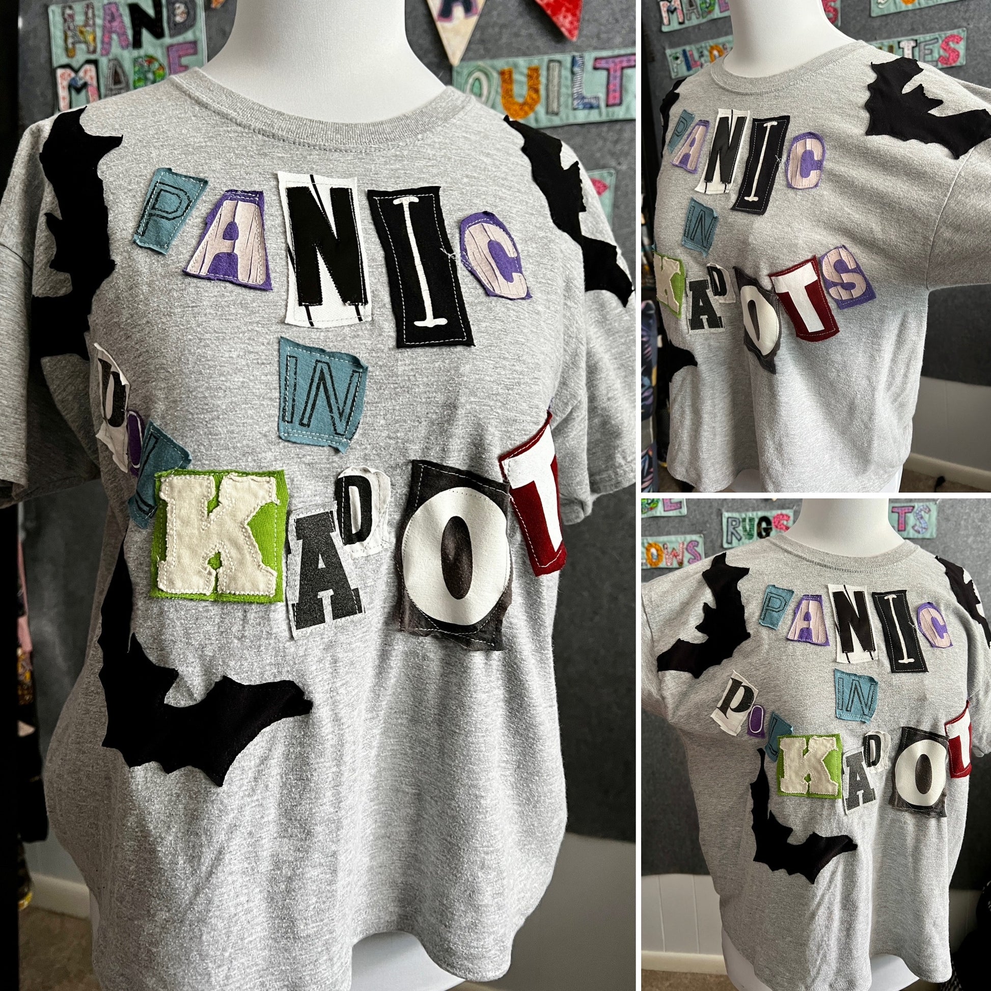 a grey tshirt with various letters reading "Panic in Polkadots" and black bats all around