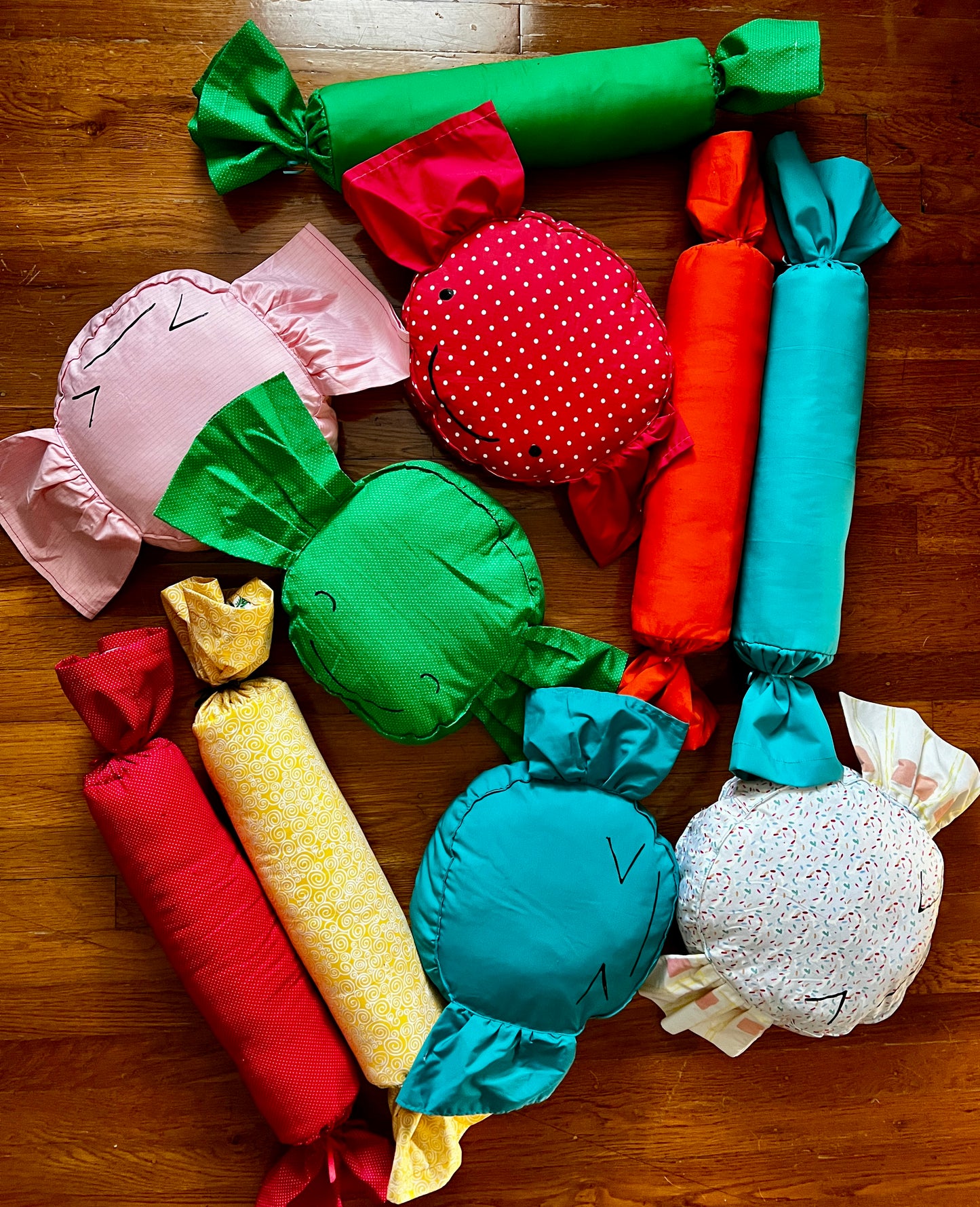 a group of cute candy pillows, in various bright colors, against a wood background