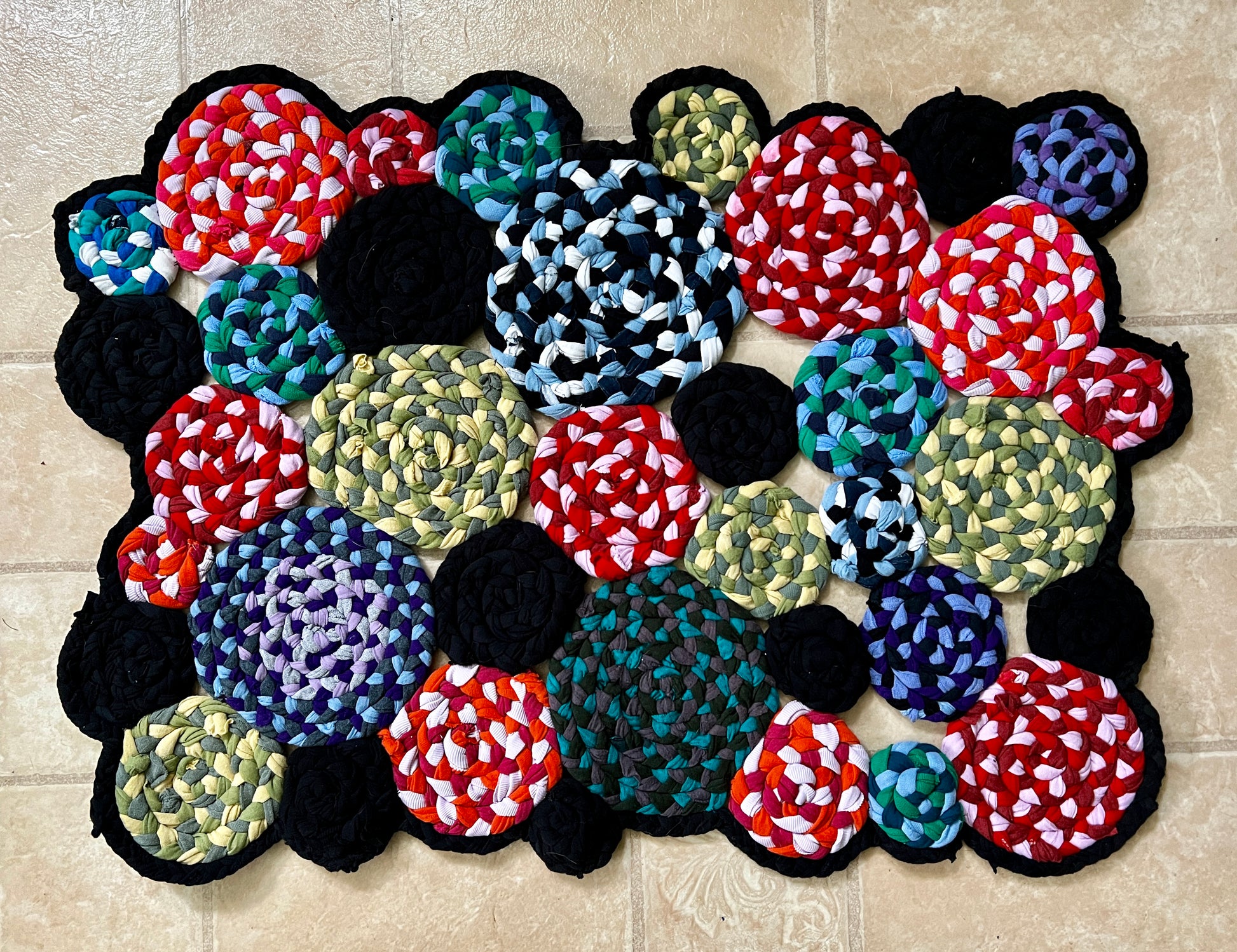 a circle collage handbraided and hand sewn doormat rug in vibrant colors