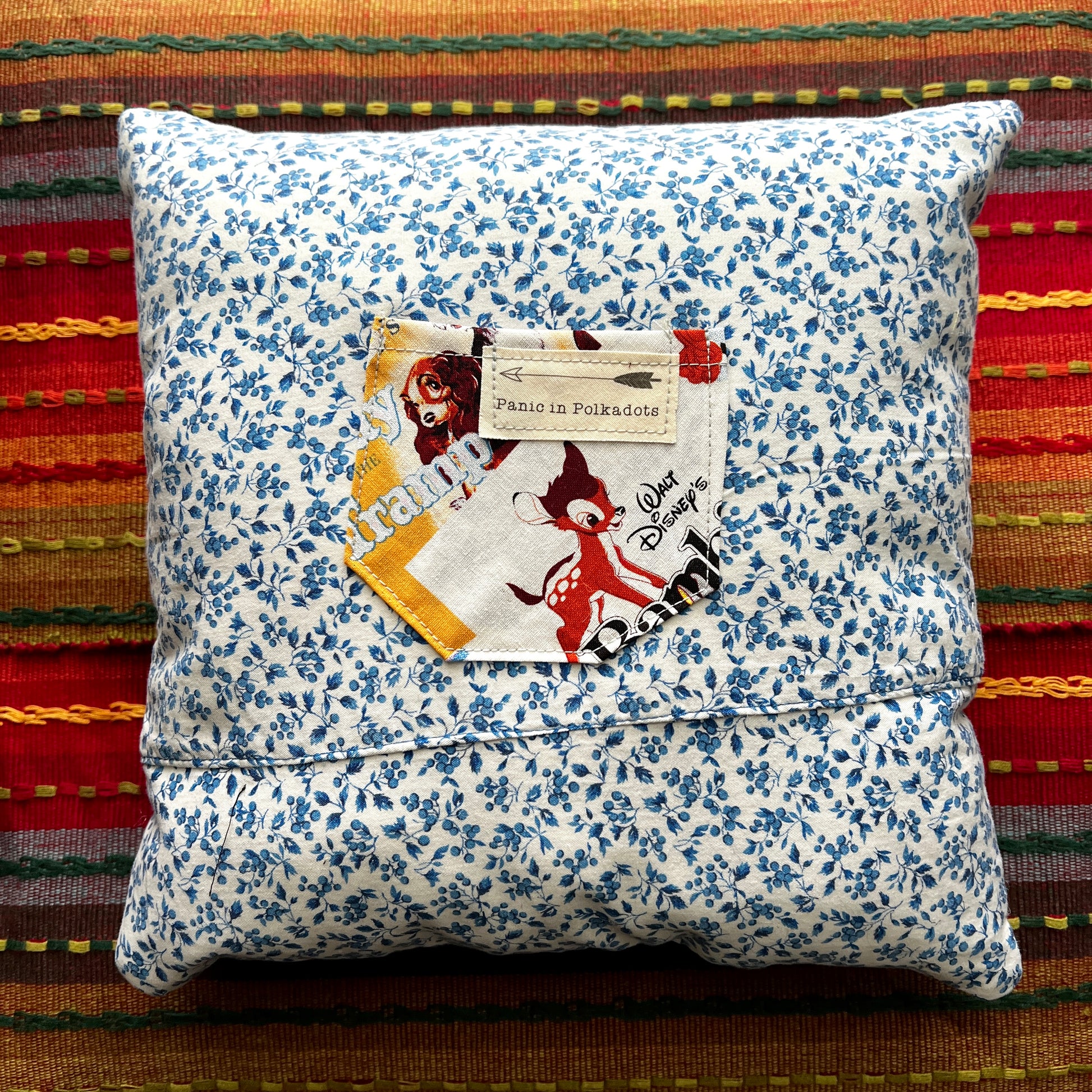 back view of disney dumbo cathedral square pillow, with blue florals and bambi movie poster