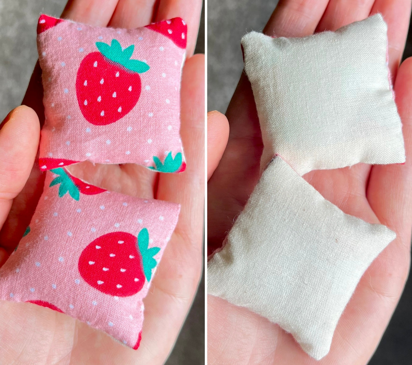 Two small fabric pillows, front with strawberry pattern and back is plain white, held in hands.