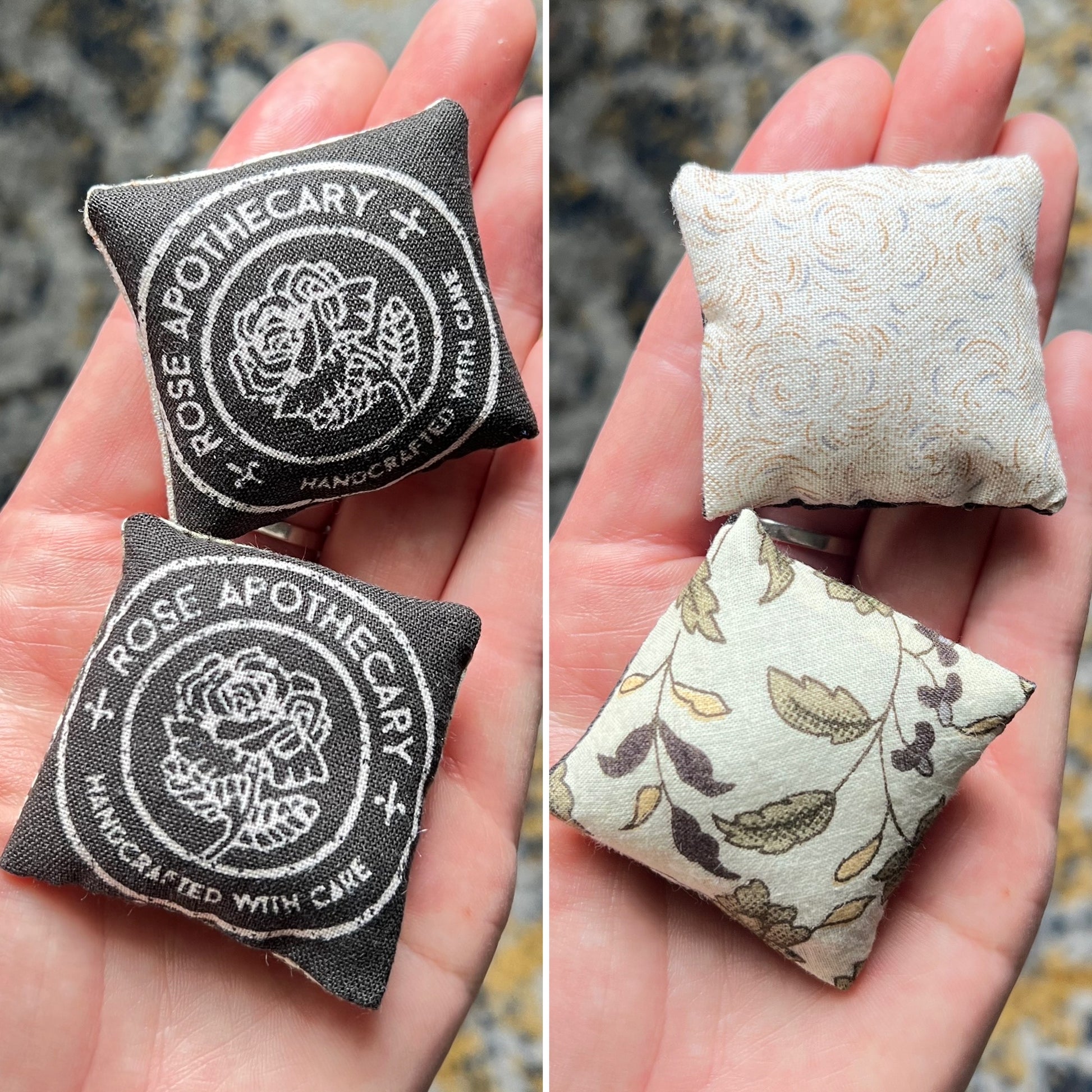 Two small fabric pillows with 'Rose Apothecary' on the front, and different ivory patterns on the backs, held in hands.