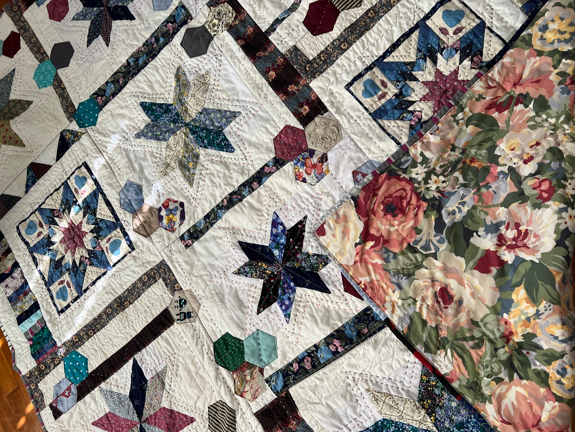 front of stars and hexies quilt, with one corner folded up to show background