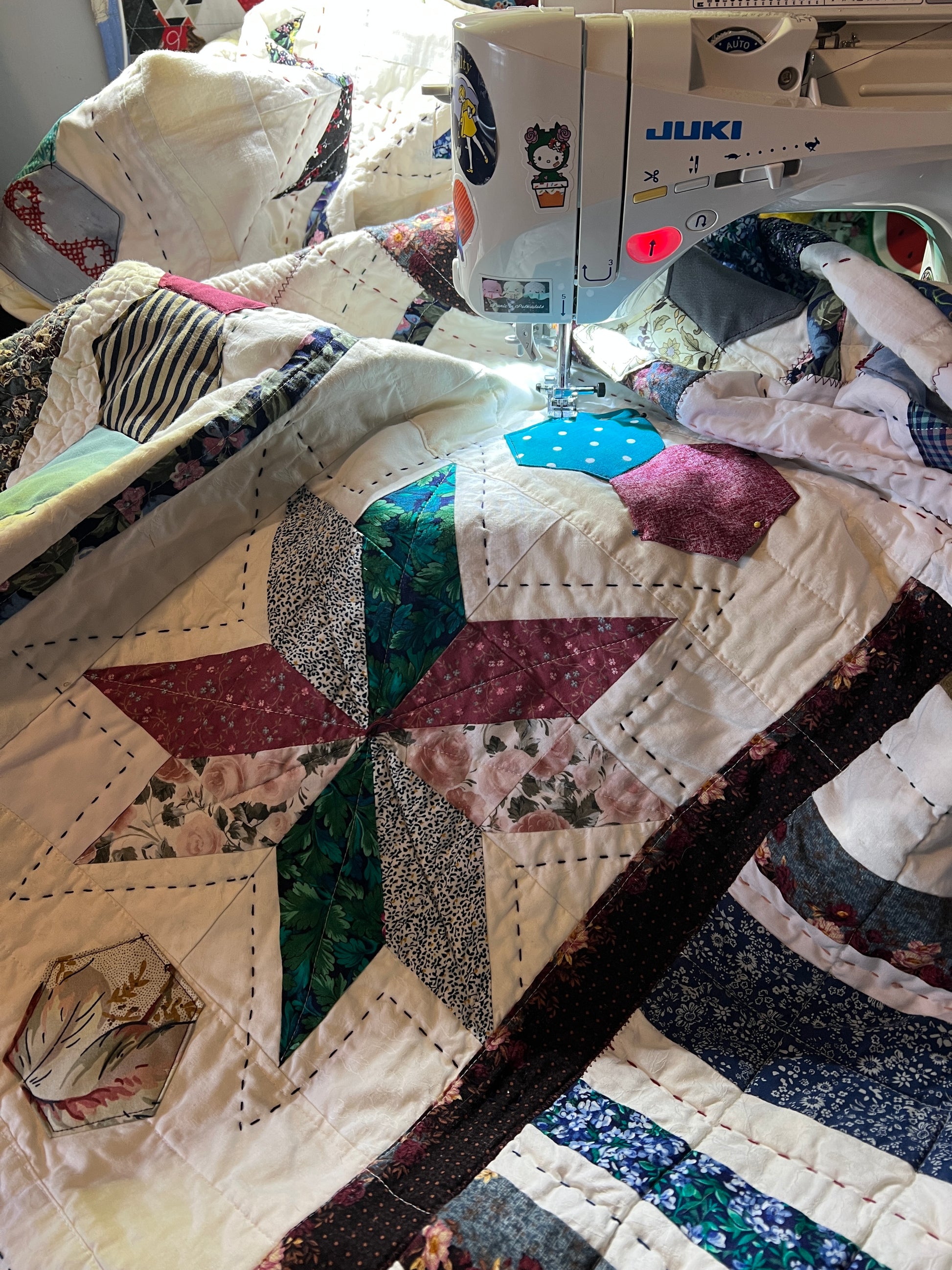A quilt with eight point stars and quilted hexies, on the sewing machine