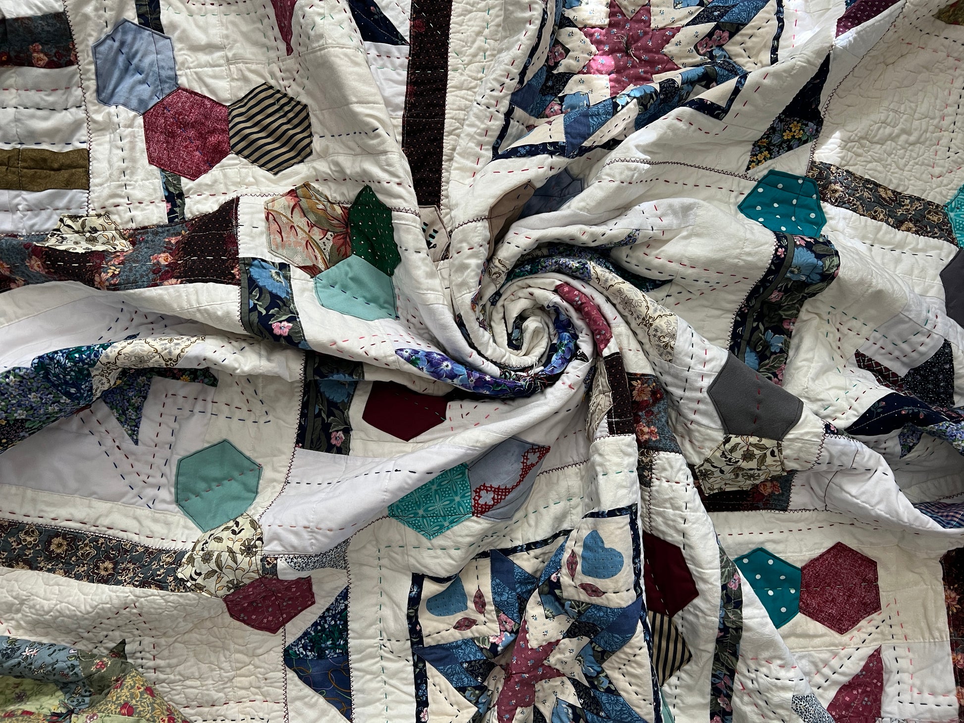 eight point stars, and scrappy hexagons quilt, swirled in center to show texture