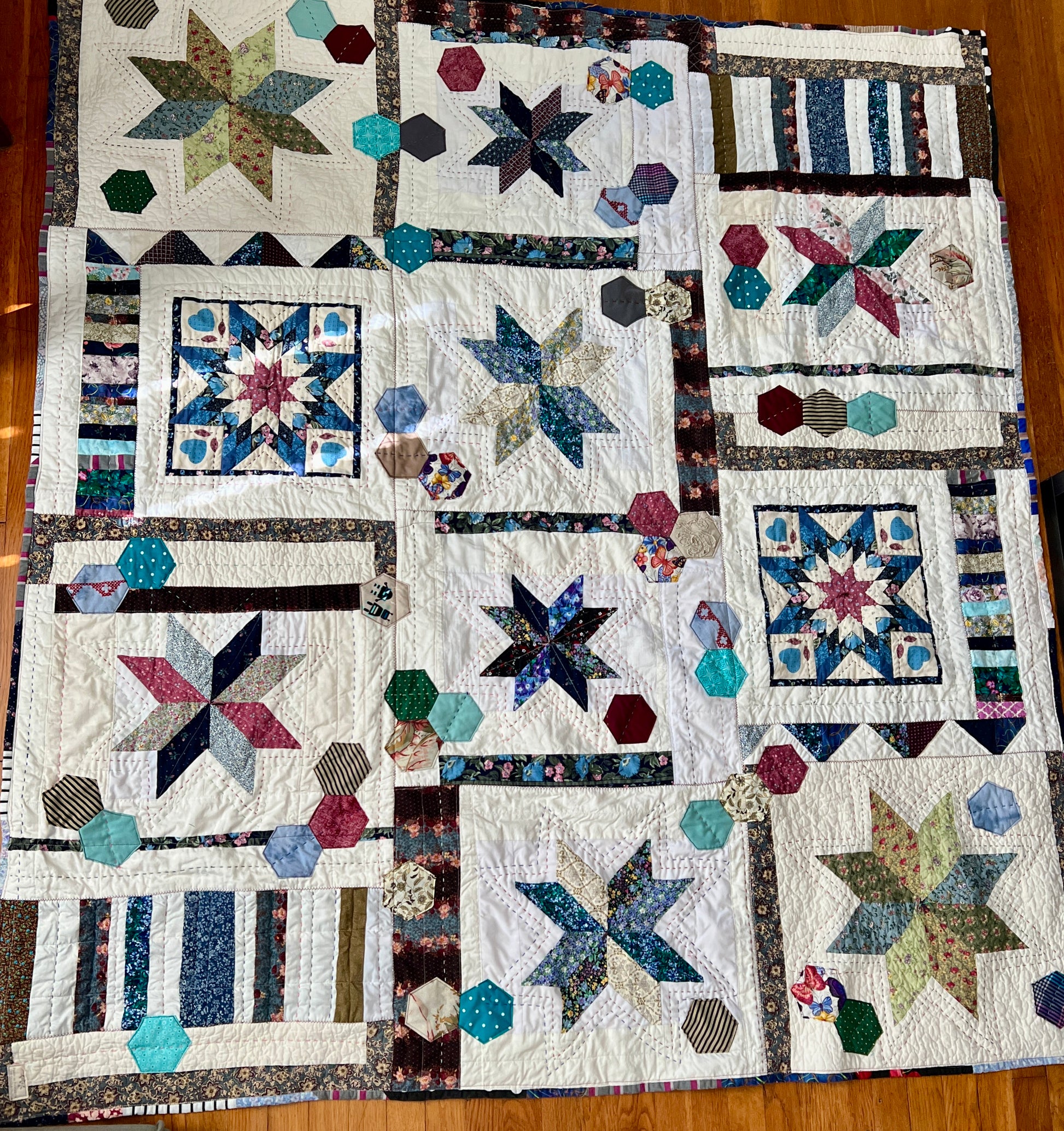 front of stars and hexies quilt, lay flat on a wood background