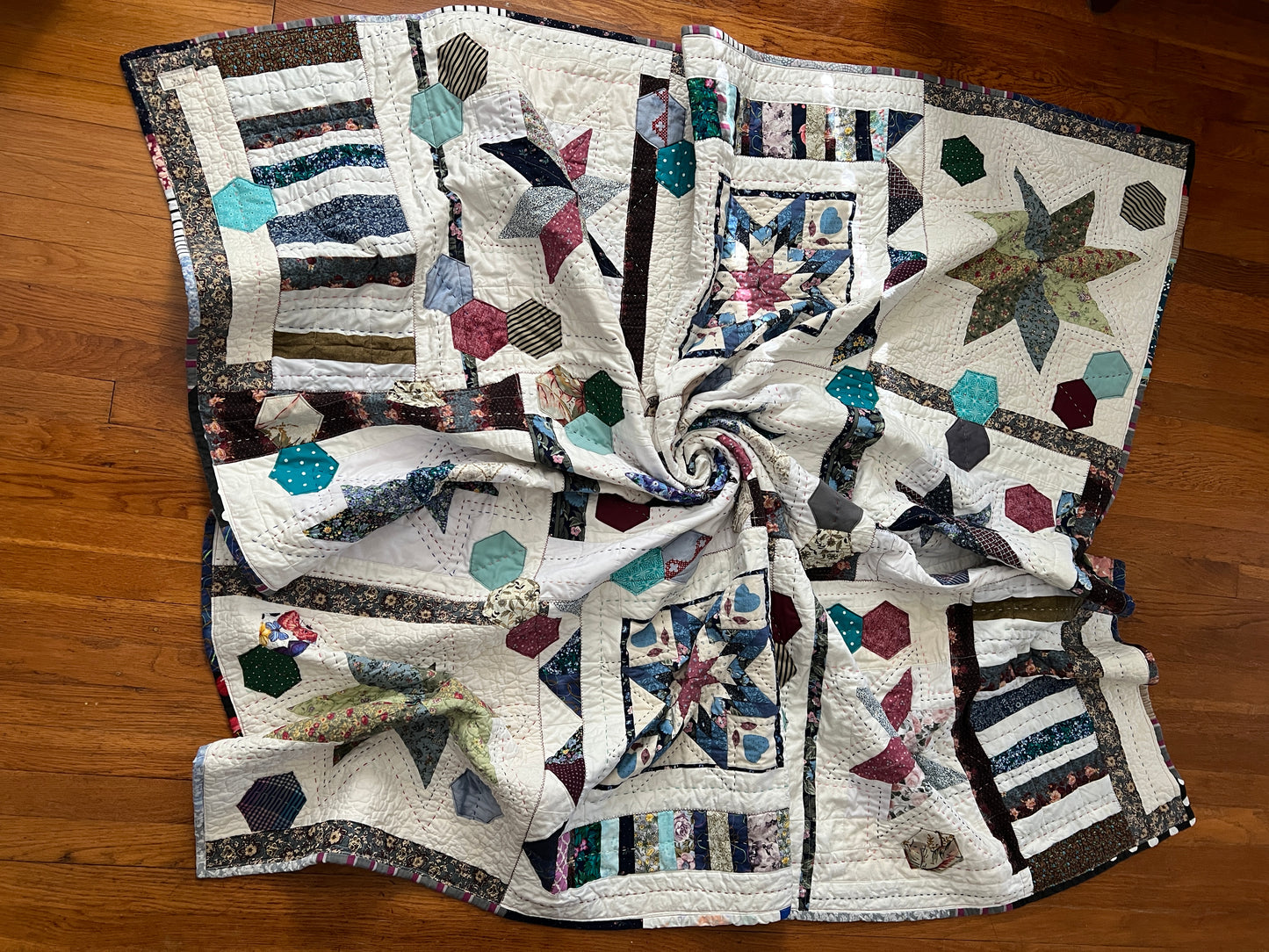 eight point stars and quilted hexies quilt, twisted in the middle to show texture