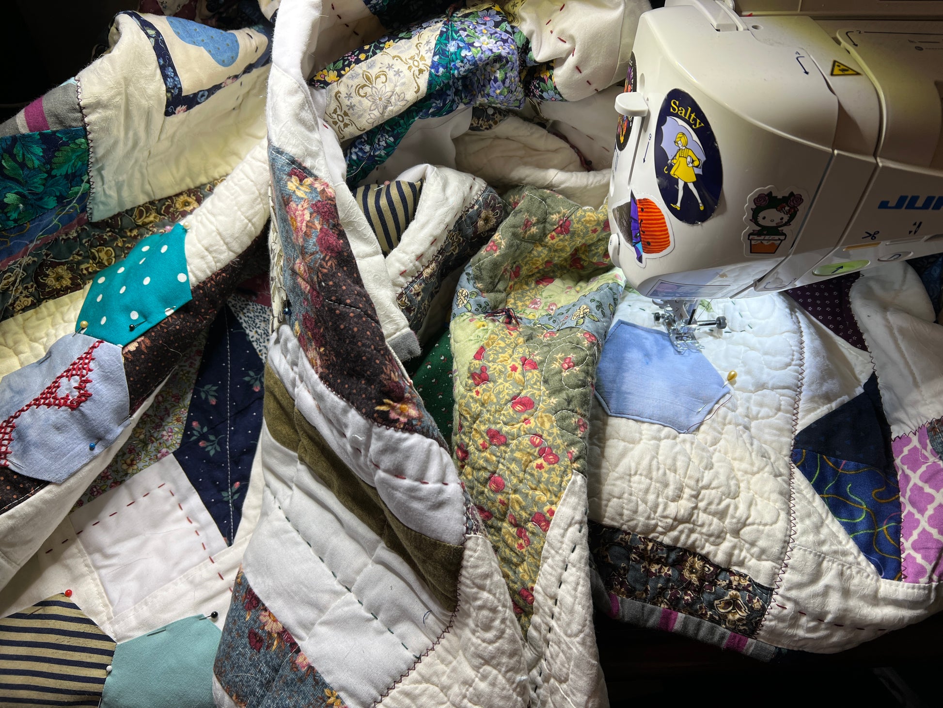 A quilt with eight point stars and quilted hexies, as a work in progress on the sewing machine