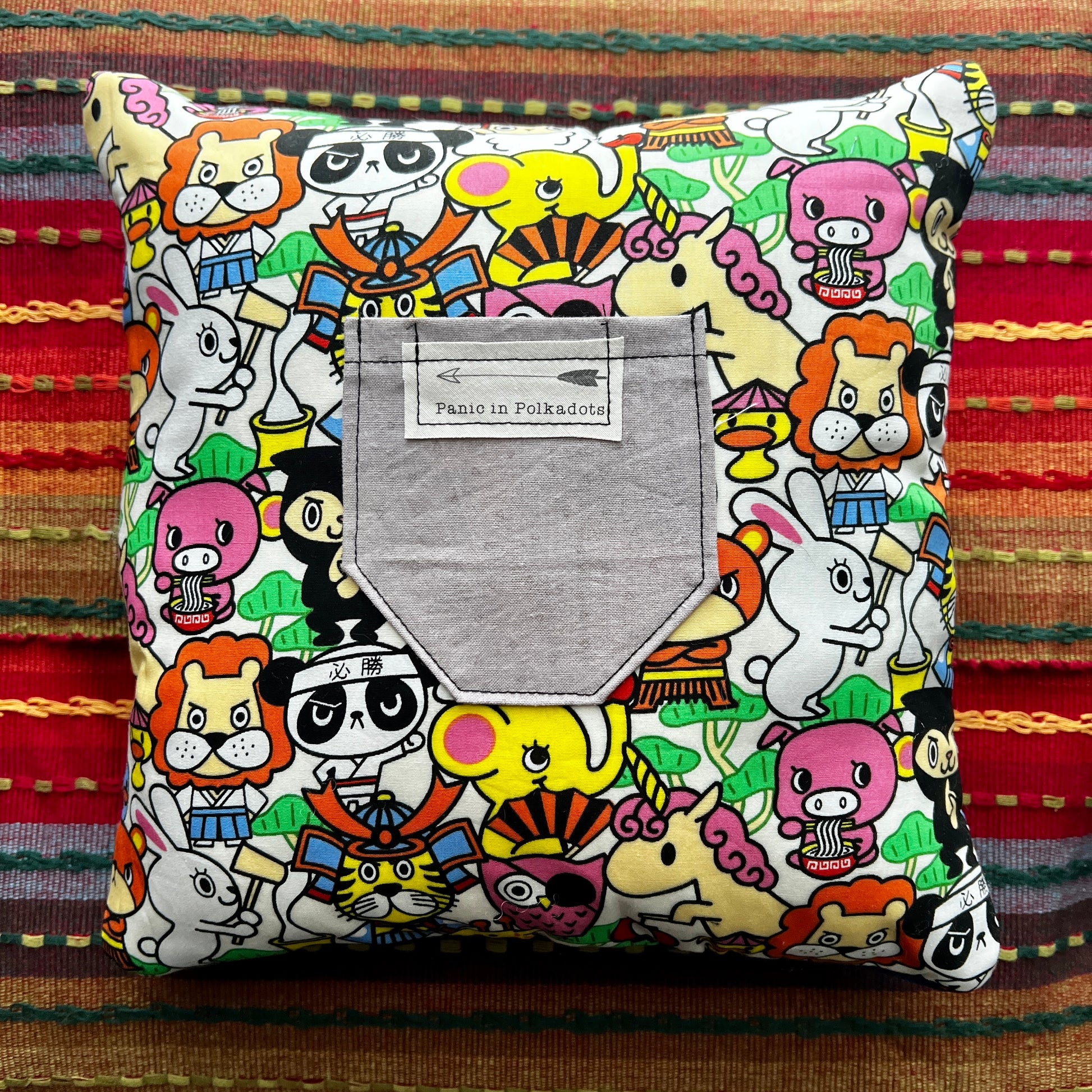 back view of film cameras cathedral square pillow, with colorful cartoon characters