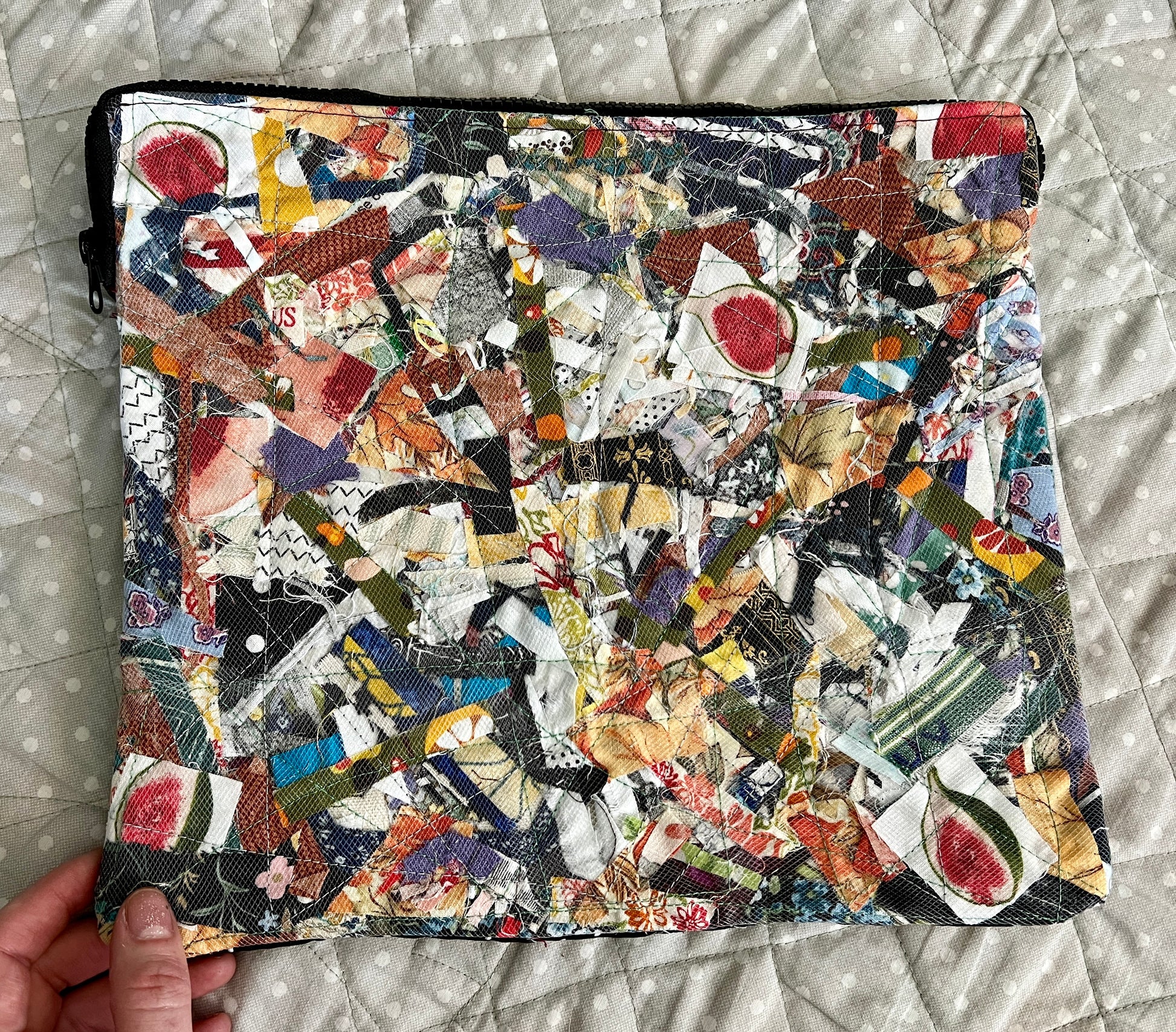 ipad case held in the corner for scale, against a polkadot quilt background