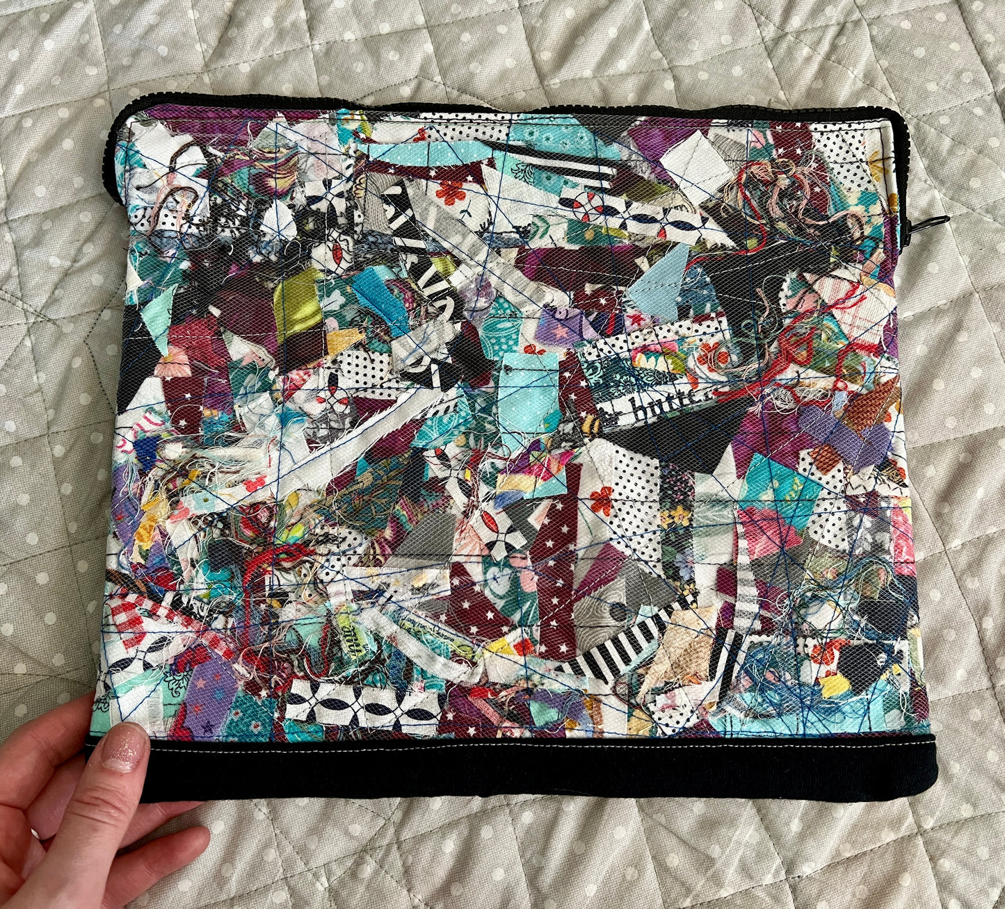 ipad case held in the corner for scale, against a polkadot quilt background
