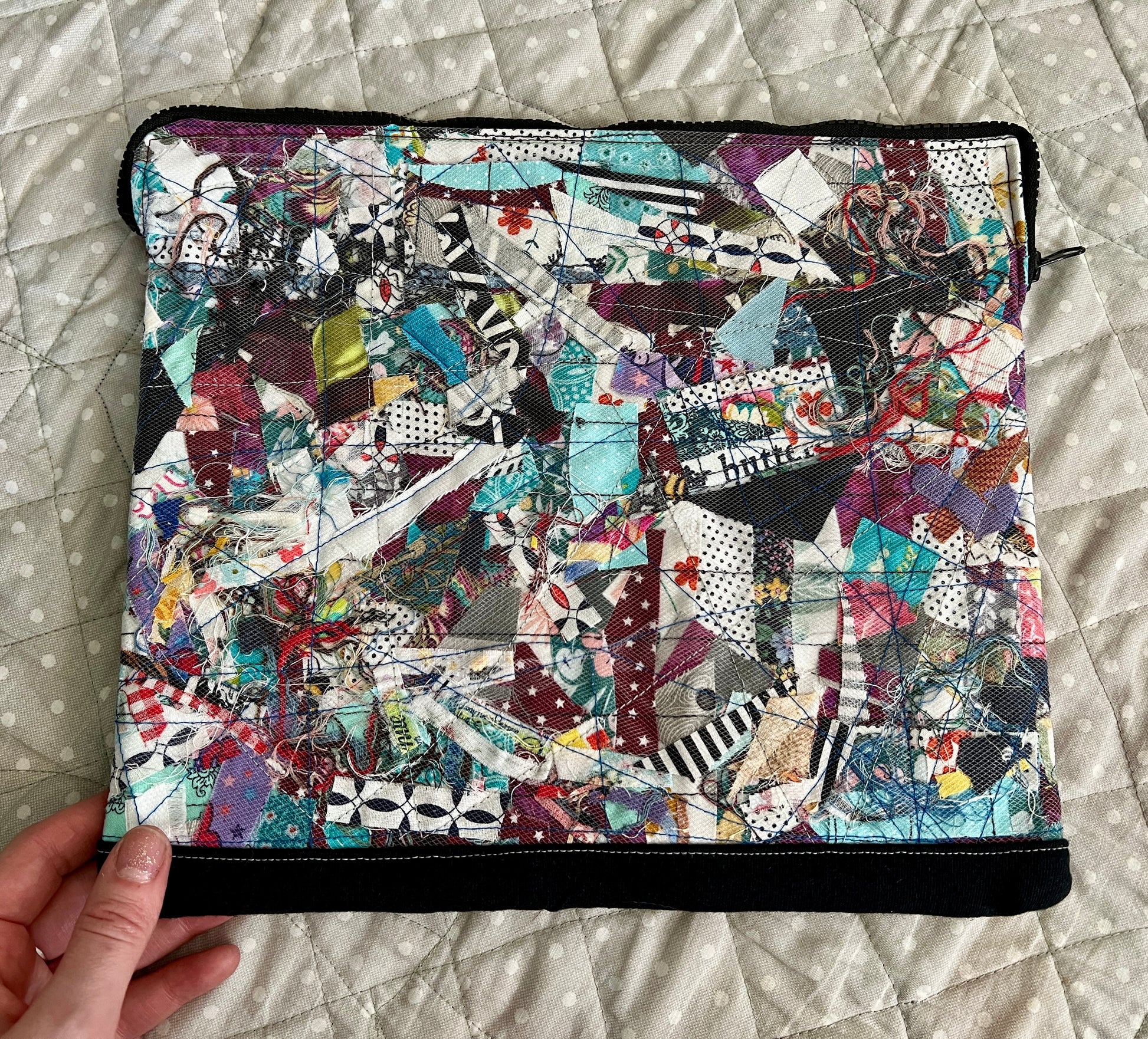 ipad case held in the corner for scale, against a polkadot quilt background