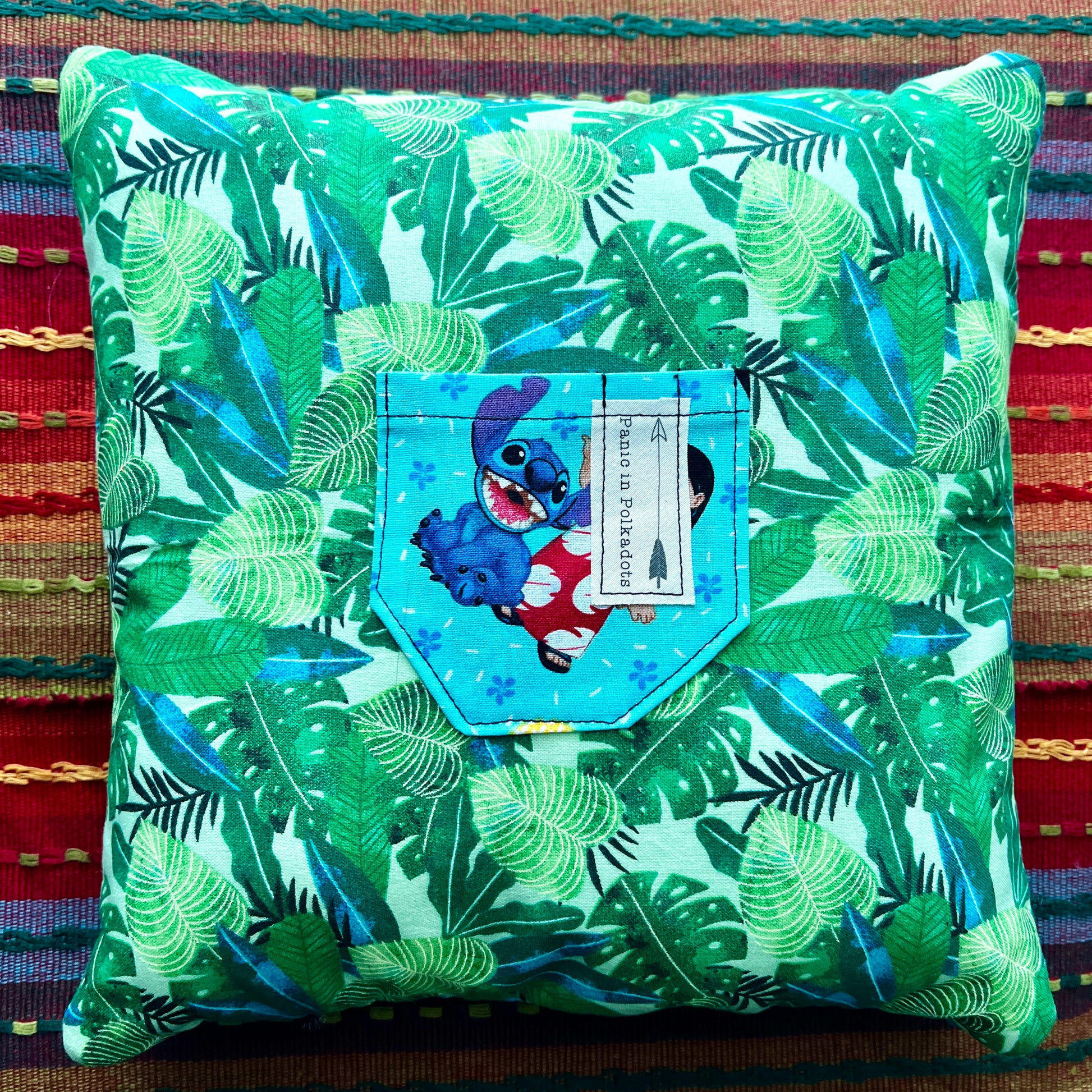 back view of lilo and stitch cathedral square pillow, with green leaves and stitch pocket