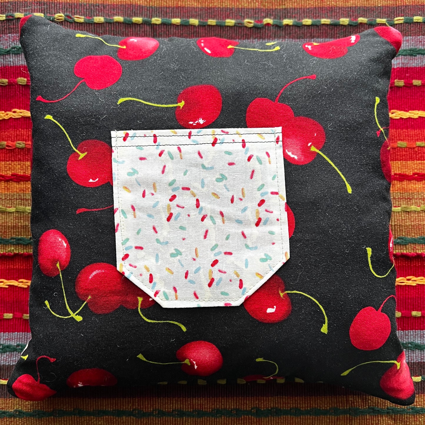 back view of lilo and stitch red cathedral square pillow, with cherries and sprinkles