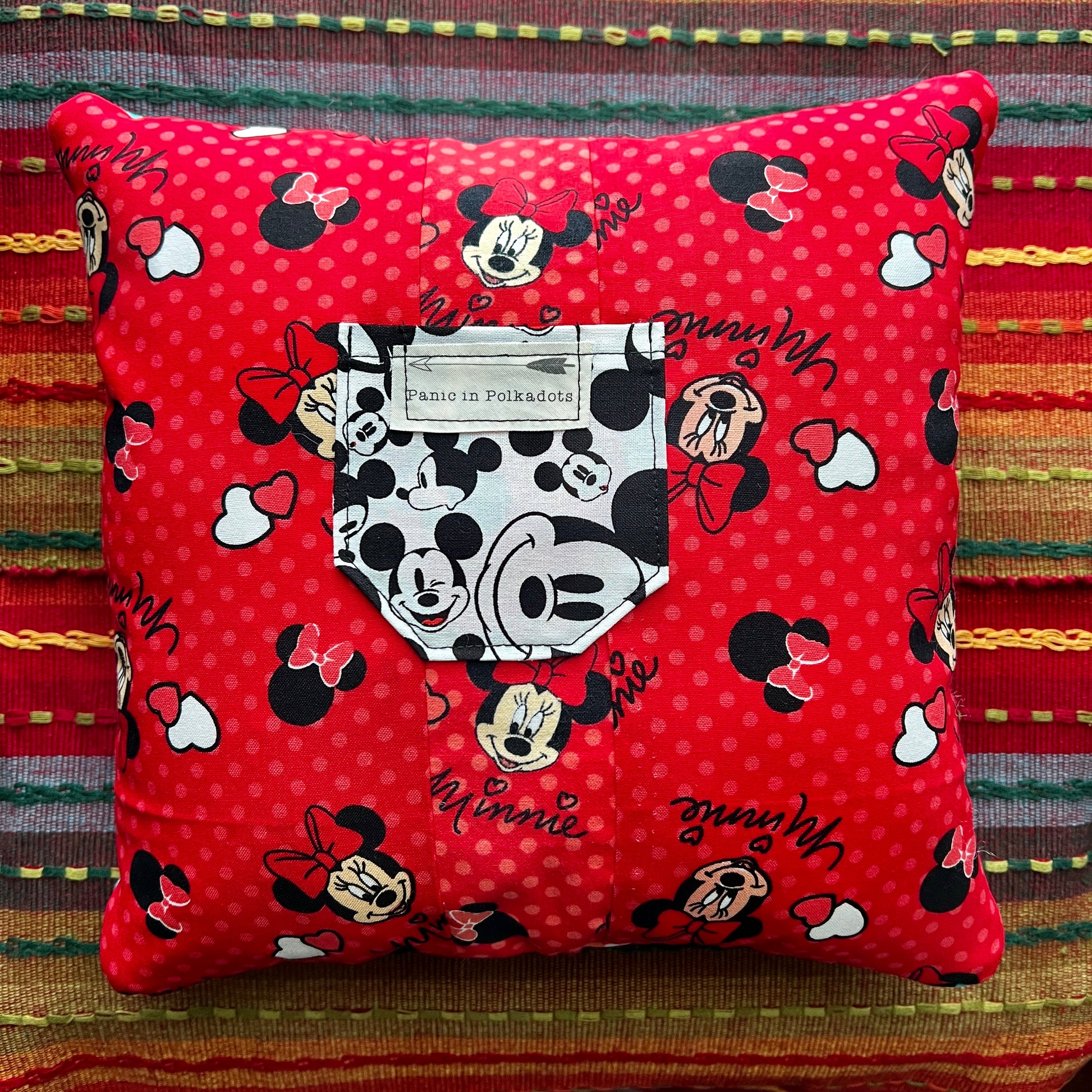 back view of minnie and mickey mouse cathedral square pillow, with red minnie print and mickey pocket
