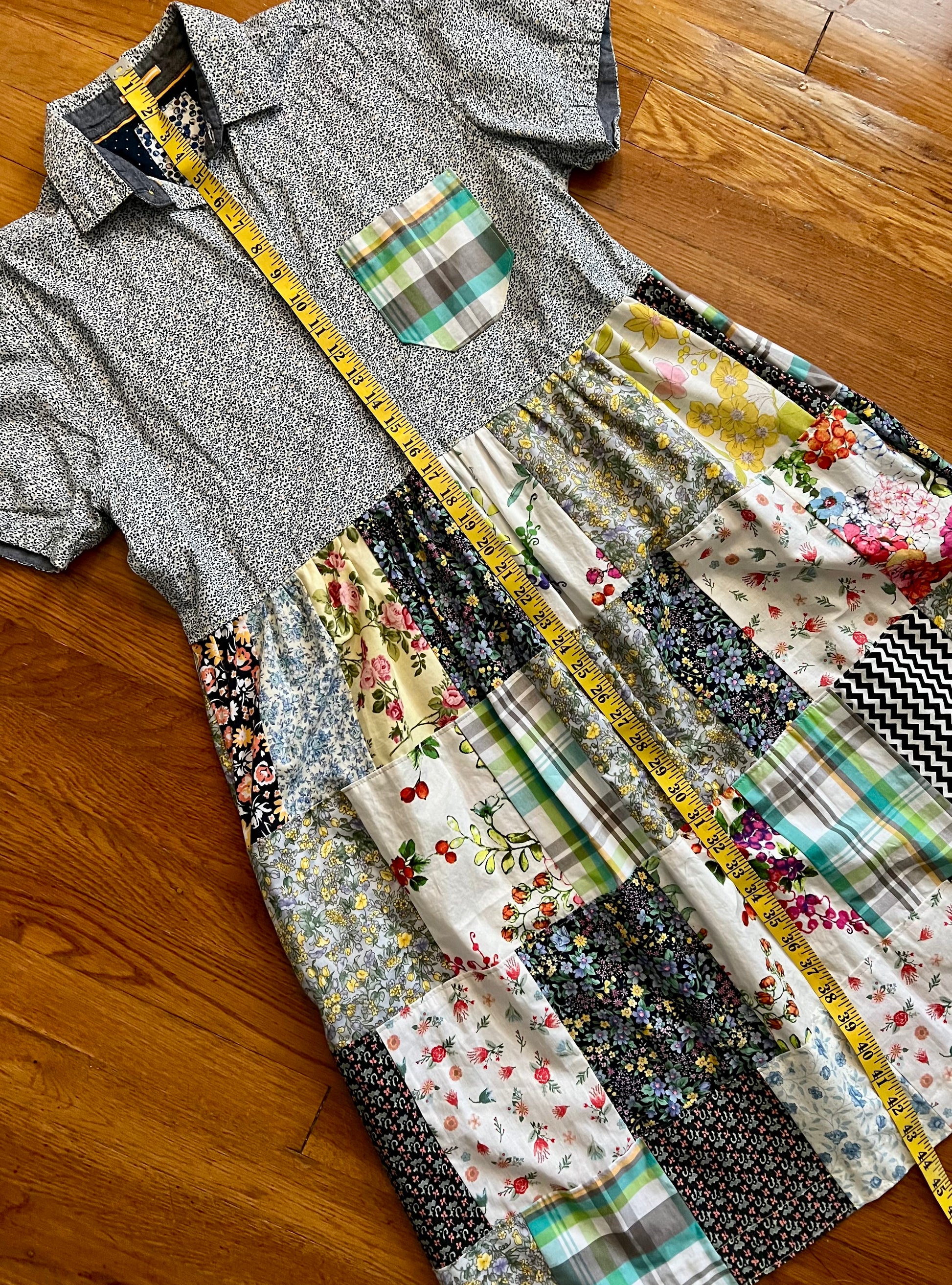 a patchwork shirt dress, with button-up top part, and patchwork shirt bottom part. on a wood floor background