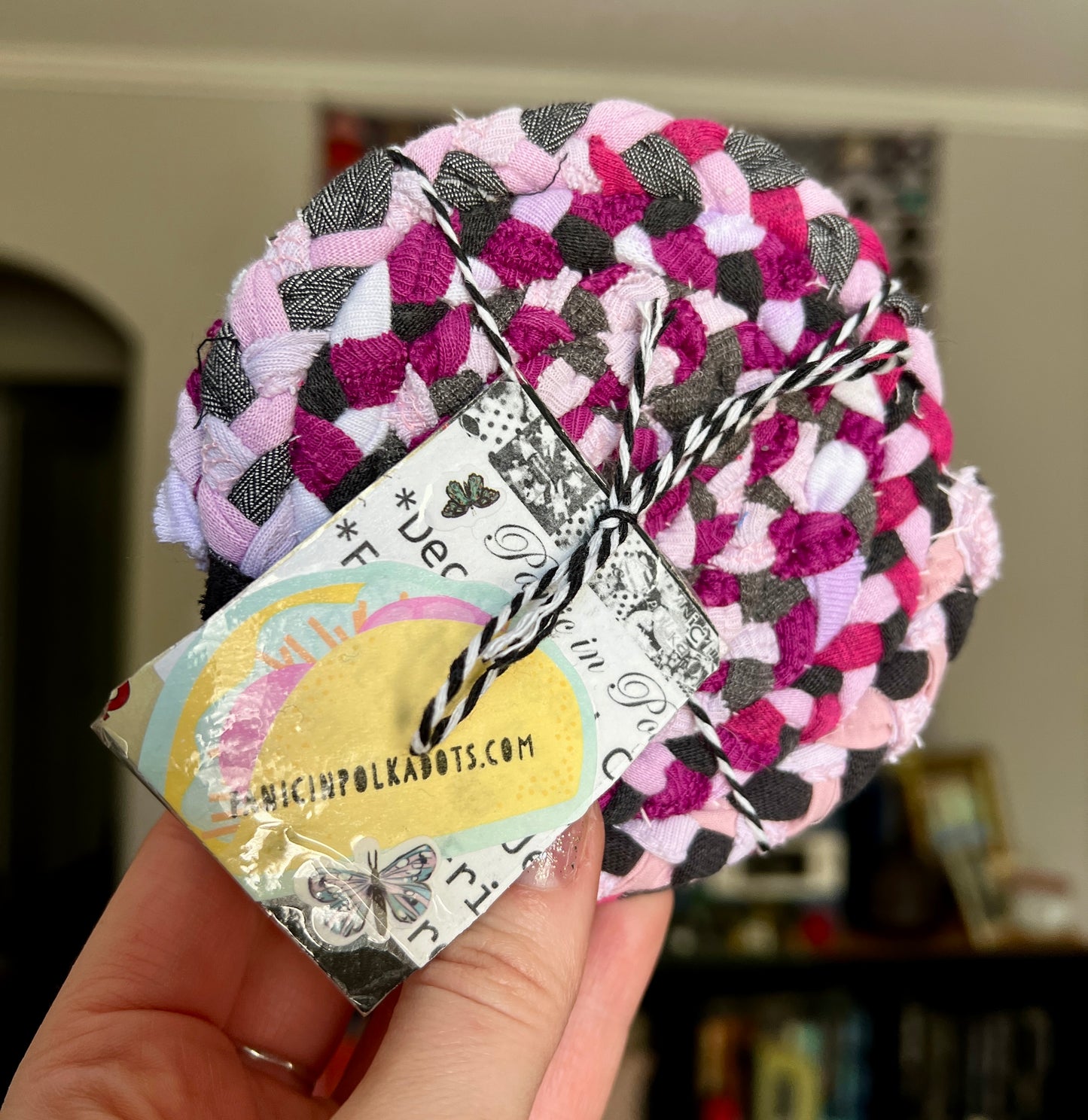 pink coasters, held up hand for scale, a tag with taco and Panicinpolkadots.com