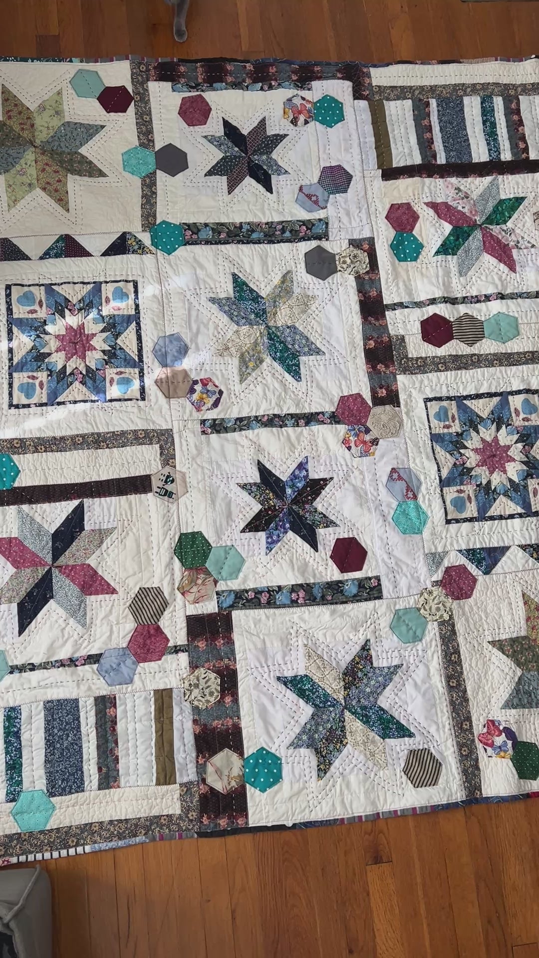 A quilt with eight point stars and quilted hexies, as the camera pans across the front of the quilt