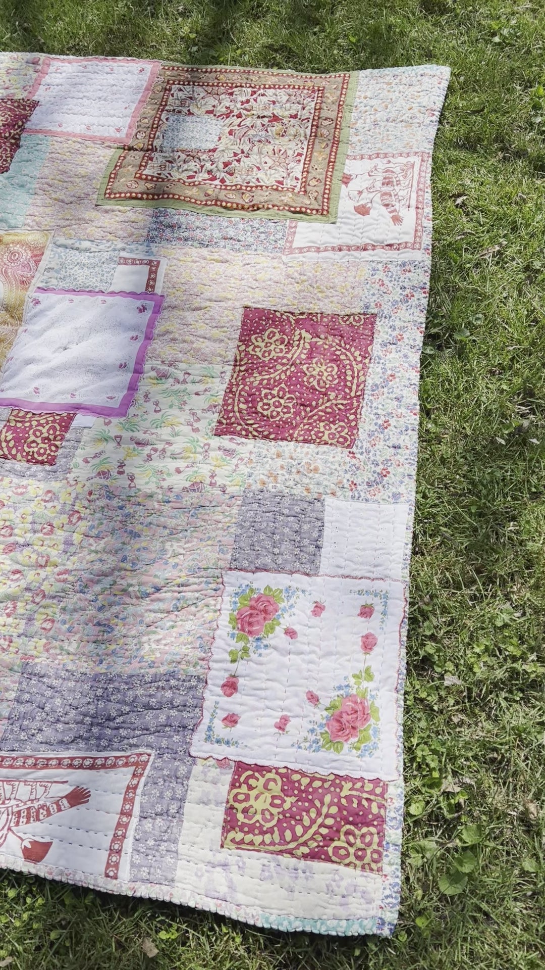 a video of the quilt, outside against a green lush background, birds chirping in distance