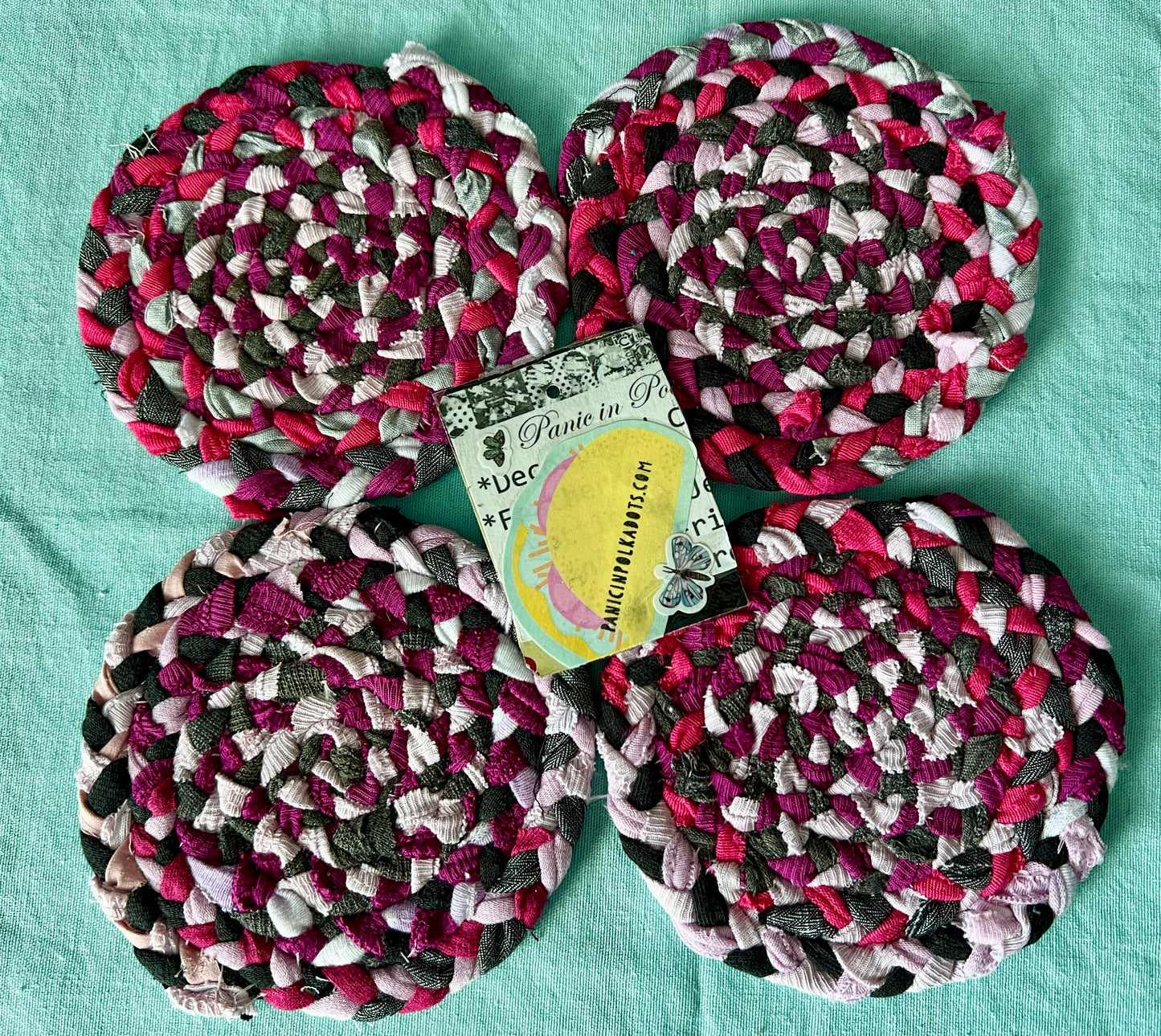 set of four handbraided handstitched coasters hot pink, aerial view with Panic in Polkadots tag in middle