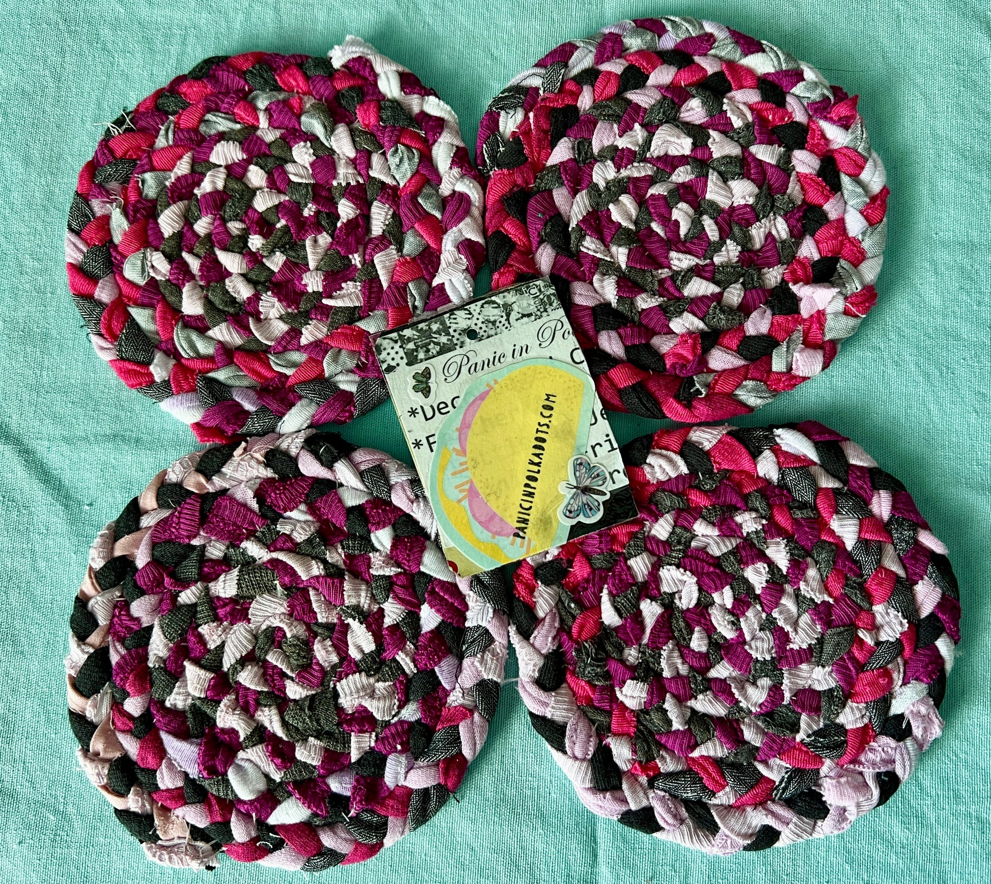 set of four handbraided handstitched coasters hot pink, aerial view with Panic in Polkadots tag in middle