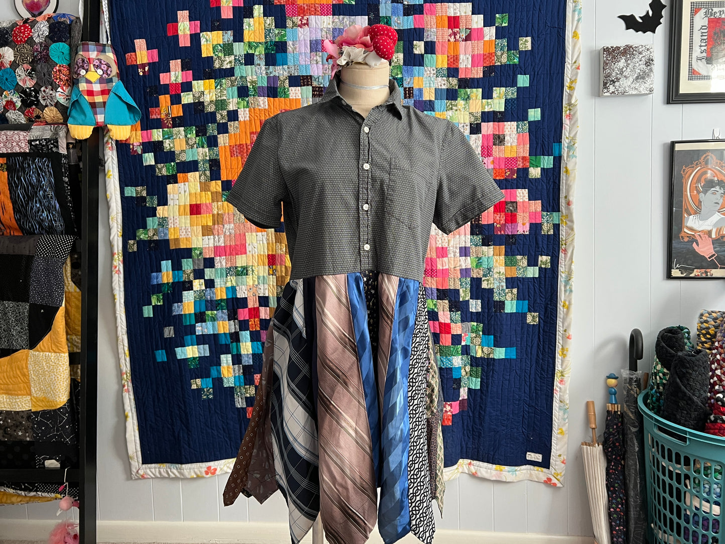 a small necktie shirtdress on a mannequin against a colorful quilt background