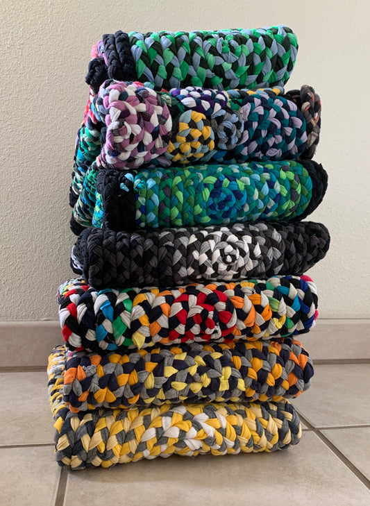 stack of handmade rugs, all handbraided and handsewn using upcycled tshirt fabrics