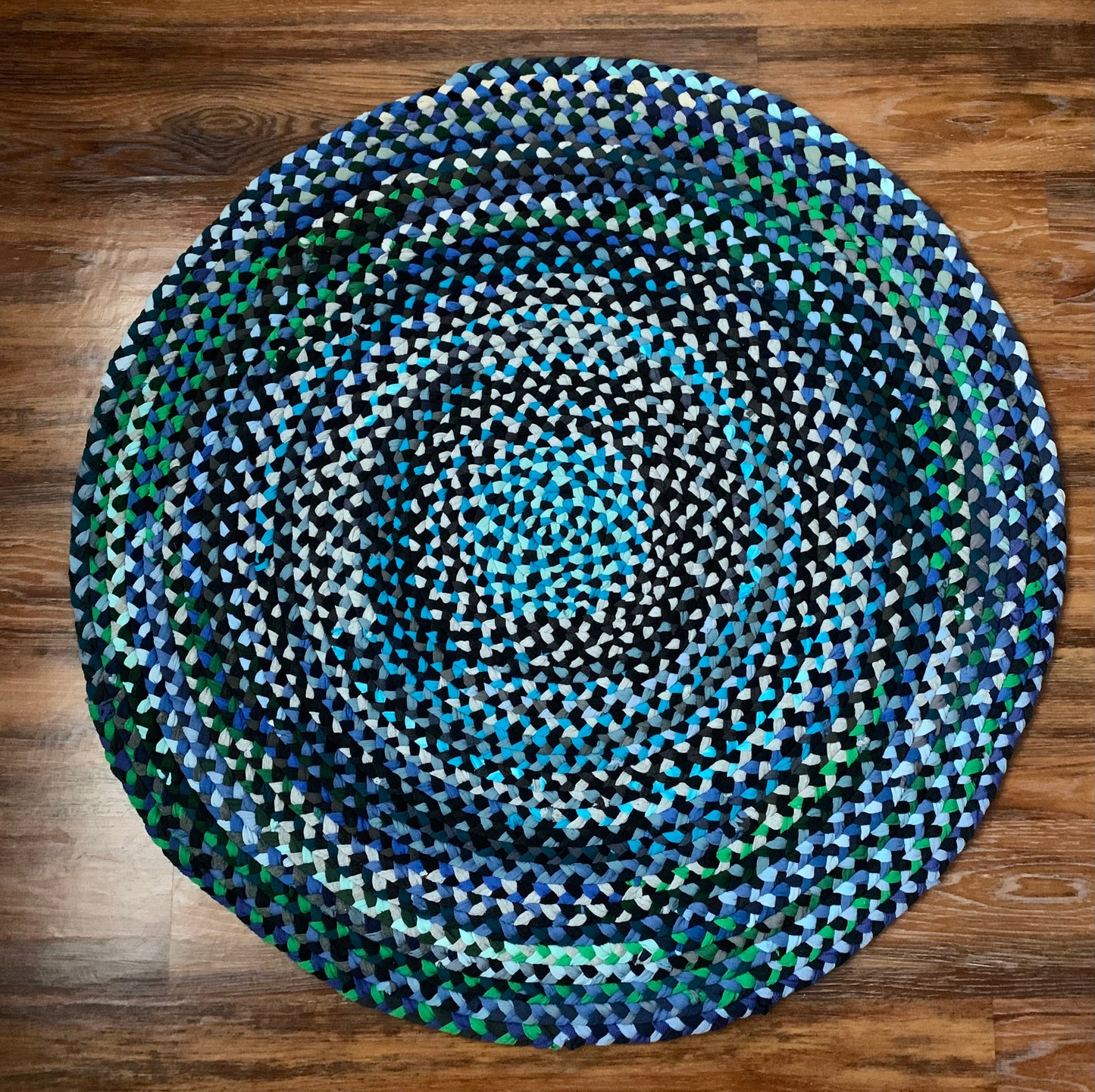 aerial view of the top of the tshirt rug, with variations of blues, greens, turquoise and teal throughout